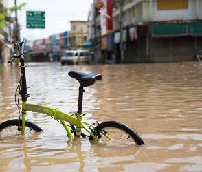 Closeup of a bicycle submerged in flood water in a Vietnamese city street.